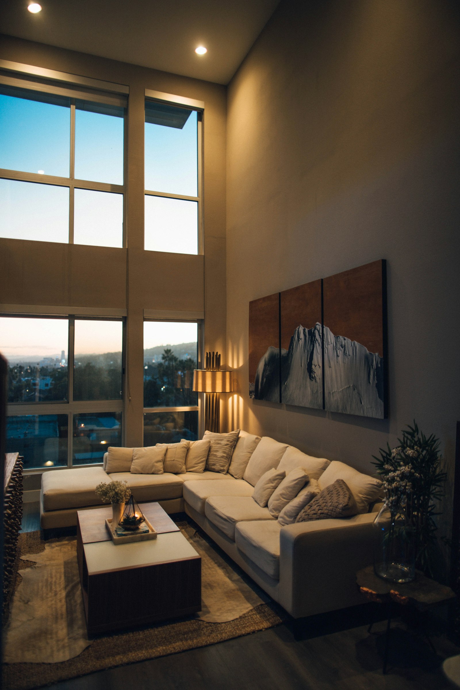 Warm, light-filled apartment living room at dusk